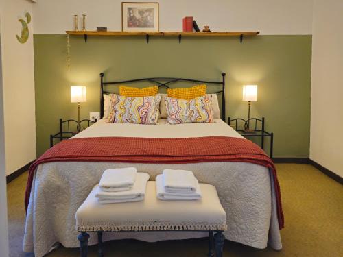 a bedroom with a large bed with two folded towels at Apartamento con jardín y terraza Casa San Pablo in Melide