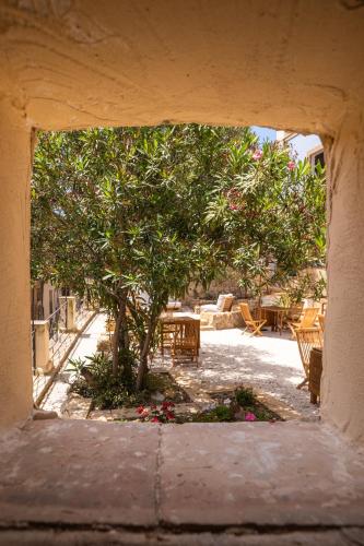 an opening in a building with a tree and flowers at Villa Amoroso - Ospitalità Mediterranea in Agrigento