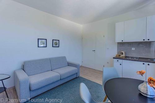 a living room with a blue couch and a table at Hotel Central Vlasic in Vlasic