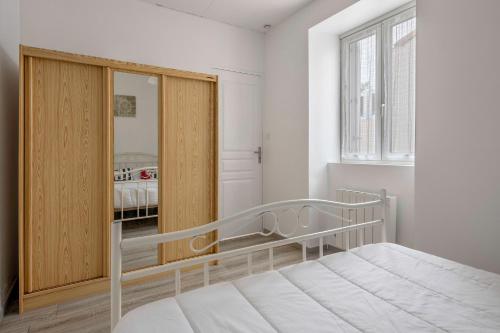 une chambre avec un lit et une armoire en bois dans l'établissement Maison pour 5 à 350m de la plage, à La Bernerie-en-Retz