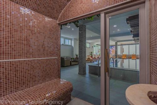 a room with a brick wall with a bench in a house at Hotel Central Vlasic in Vlasic