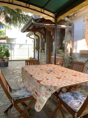 a table and chairs under an umbrella on a patio at La Casina del Delta del Po in Porto Viro