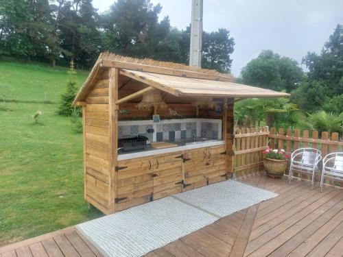a small wooden building with a kitchen on a deck at Gîte et Chambres d'Hôtes du Petit Moulin in Réaumur
