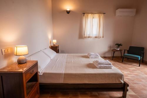 a bedroom with a bed and a table and a chair at Villa Amoroso - Ospitalità Mediterranea in Agrigento
