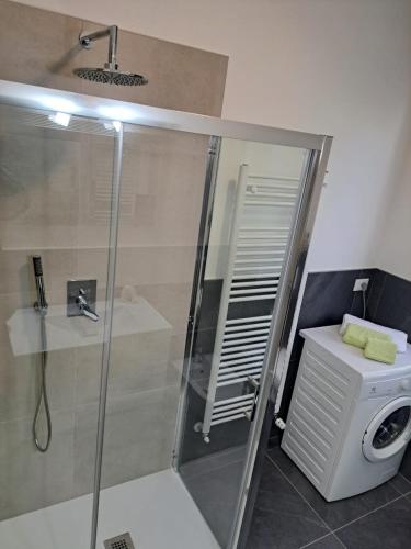 a bathroom with a shower and a washing machine at Casa Fontana Rossa 2 in Arizzano
