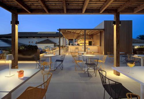 a restaurant with tables and chairs on a patio at Impressive Playa Granada Golf in Motril