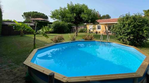 une grande piscine bleue dans une cour dans l'établissement Comfortable house between Ocean and Bay, à La Celle-sous-Gouzon