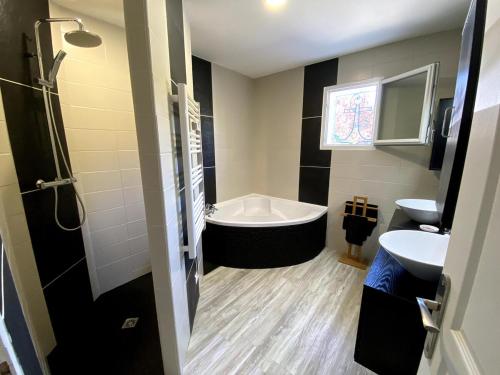 une salle de bain avec une baignoire et un lavabo dans l'établissement Comfortable house between Ocean and Bay, à La Celle-sous-Gouzon