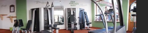 a gym with rows of tread machines in a room at Kirchenwirt in Reith im Alpbachtal