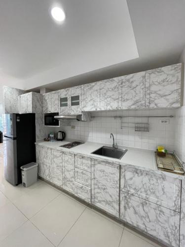a white kitchen with a sink and a refrigerator at View Talay 6 Pattaya Beach by Anatolia Condo Suite in Pattaya