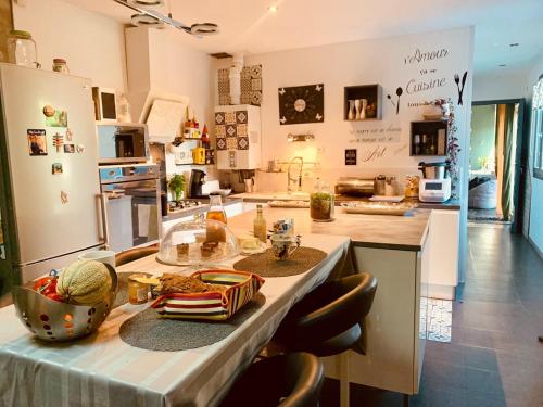 une cuisine avec un comptoir, une table et des chaises dans l'établissement Charmante maison au calme avec jardin à 5mn de île de Ré, à La Rochelle