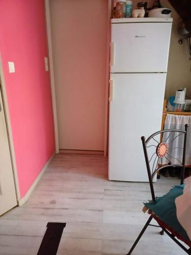 Il comprend une cuisine équipée d'un réfrigérateur blanc et d'une chaise. dans l'établissement Nuj House, à Les Mayons