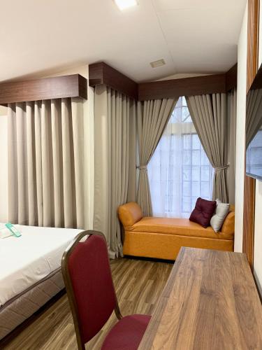 a bedroom with a bed and a table and a window at Yuhum Bed & Breakfast in Bacolod