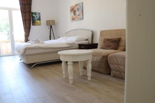 a bedroom with a bed and a table and a couch at Aparmani Park Centar in Trebinje