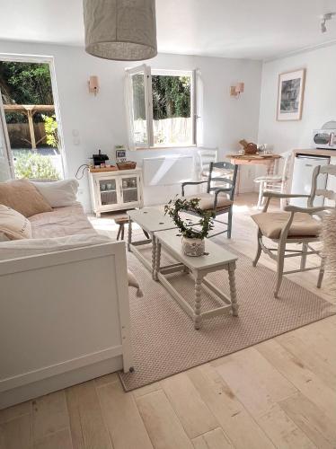 un salon avec un canapé, des chaises et une table dans l'établissement La Maison de Manou, à La Noë-Poulain