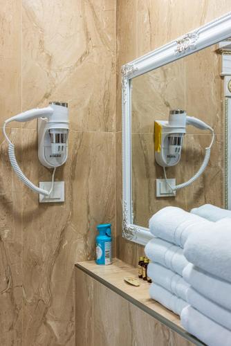 a bathroom with a mirror and a pile of towels at Elijos Kopa in Šventoji