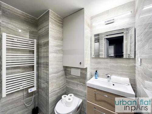 une salle de bain avec un lavabo, des toilettes et un miroir dans l'établissement Urban Flat 02 - 4 Bedrooms Flat in center of Paris, à Paris