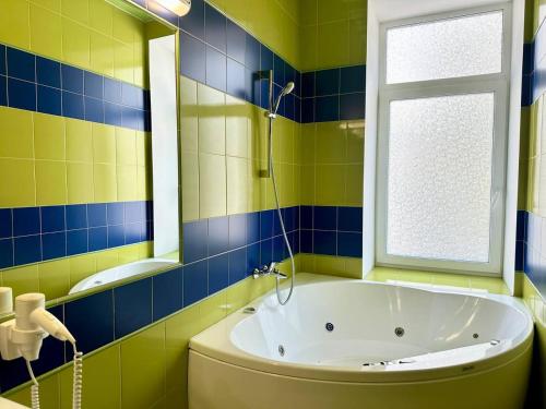 a bathroom with a tub and a window at Kievinn in Kyiv
