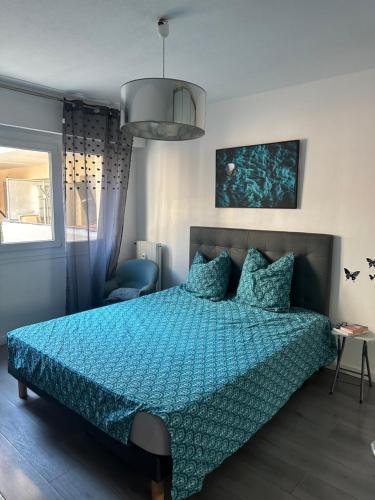 - une chambre avec un lit bleu et une couette bleue dans l'établissement 3 pièces calme 5 mn Port, à Nice