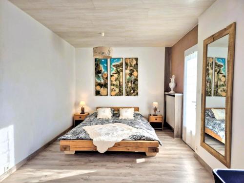 une chambre avec un lit et deux tableaux au mur dans l'établissement La Maison Martana, à Saint-Mathurin