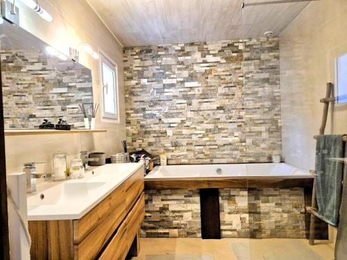 une salle de bain avec une baignoire et un lavabo dans l'établissement La Maison Martana, à Saint-Mathurin