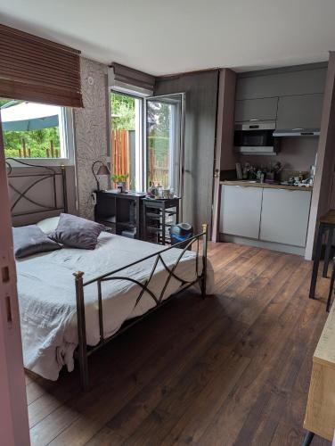 a bedroom with a bed and a kitchen at Au coeur des Rias, studio Merrien proche de la mer in Moëlan-sur-Mer