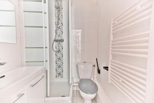 une salle de bain blanche avec toilettes et douche dans l'établissement Charmant Studio dans le centre de Paris - III, à Paris