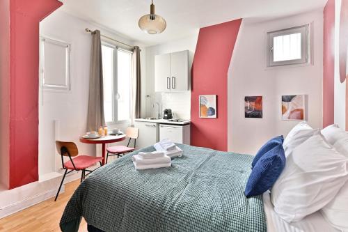 - une chambre rouge et blanche avec un lit et une table dans l'établissement Charmant Studio dans le centre de Paris - III, à Paris