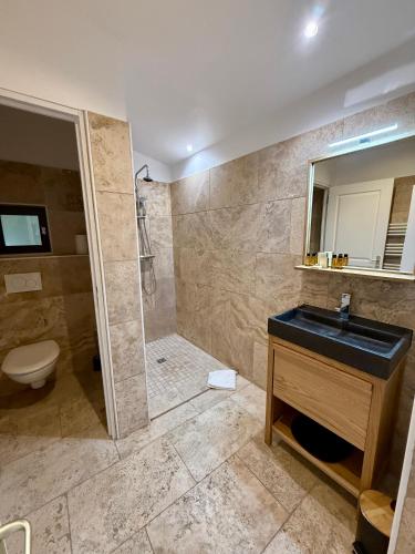 a bathroom with a shower and a sink and a toilet at La Villa Dune, Hôtel & Spa in Saint-Tropez