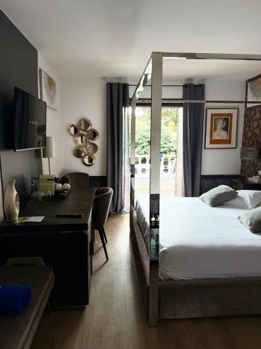 a hotel room with a bed and a desk and a desk at La Villa Dune, Hôtel & Spa in Saint-Tropez