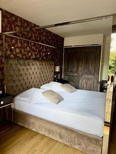 a bedroom with a large bed with white sheets at La Villa Dune, Hôtel & Spa in Saint-Tropez