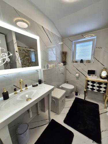 a white bathroom with a sink and a toilet at Apartment Sonja in Klimno