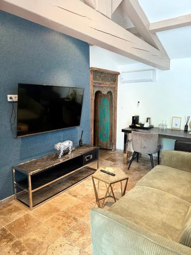 a living room with a flat screen tv on a wall at La Villa Dune, Hôtel & Spa in Saint-Tropez
