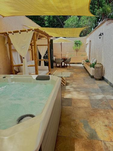 a jacuzzi tub in a patio with a table at La Villa Dune, Hôtel & Spa in Saint-Tropez