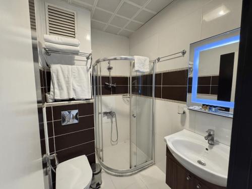 a bathroom with a shower and a toilet and a sink at Hotel Bulvar Istanbul in Istanbul