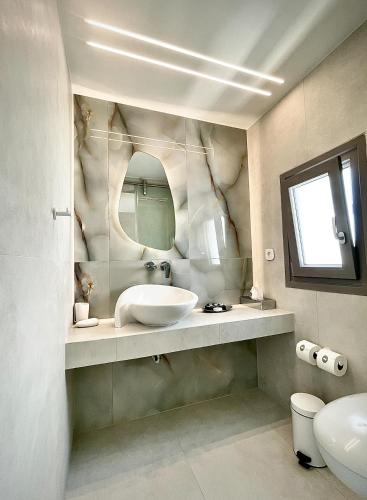 a bathroom with a sink and a mirror at Lilly Residence-All Sea View Suites, Adults Only in Naousa
