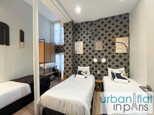 Cette chambre comprend 2 lits et un mur. dans l'établissement Urban Flat 62 - Beautiful Apartment Mermoz Champs-Elysees, à Paris