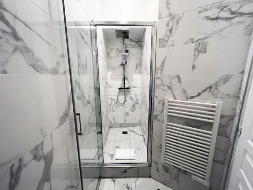 une douche avec une porte vitrée dans une salle de bain dans l'établissement Urban Flat 62 - Beautiful Apartment Mermoz Champs-Elysees, à Paris