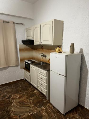 a kitchen with white cabinets and a white refrigerator at Medusa apartments in Amoudara Herakliou
