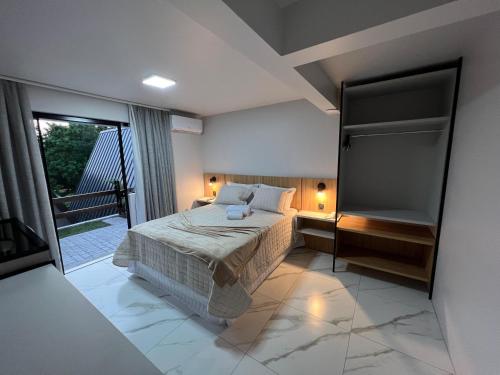 a bedroom with a bed and a balcony at Hotel e Cabanas Perau in Ametista do Sul