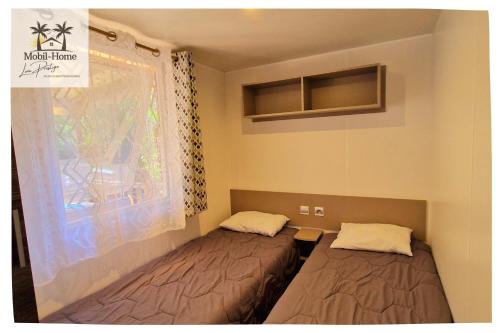 Ένα ή περισσότερα κρεβάτια σε δωμάτιο στο Mobil-home 3 chambres aux Sables du Midi à Valras-Plage
