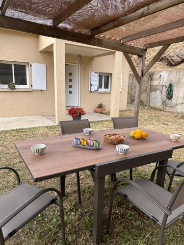 une table de pique-nique en bois avec des chaises et des fruits dessus dans l'établissement Casa Orizonte, Viggianello, à Viggianello