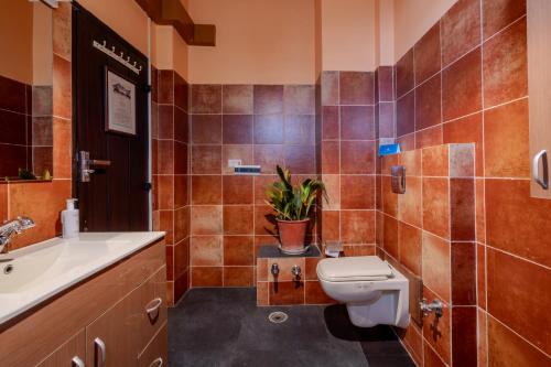 a bathroom with a toilet and a sink at SaffronStays The Divine Hima in Dharamshala