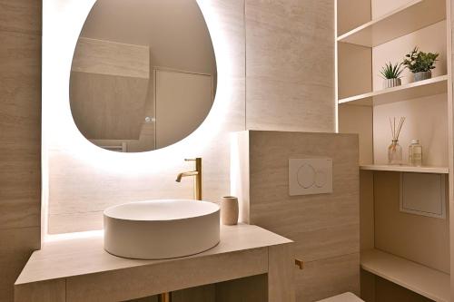 La salle de bains est pourvue d'un lavabo rond et d'un miroir. dans l'établissement Superb Apartment Center of Paris Le Marais, à Paris
