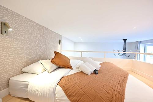 - un canapé blanc avec des oreillers dans l'établissement Superb Apartment Center of Paris Le Marais, à Paris