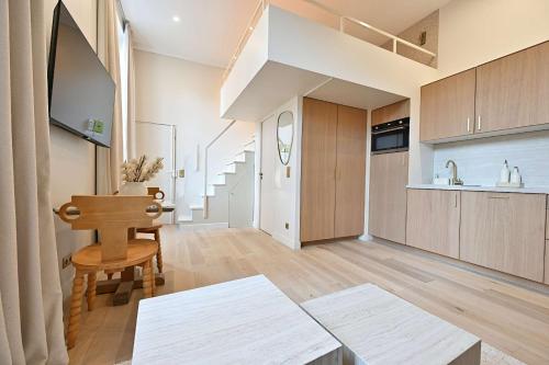 Il comprend un grand salon avec un escalier et une cuisine. dans l'établissement Superb Apartment Center of Paris Le Marais, à Paris