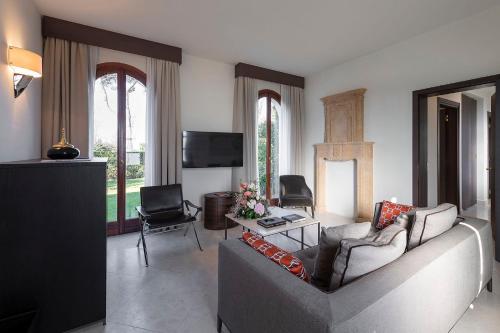 a living room with a couch and a tv at San Clemente Palace Venice in Venice