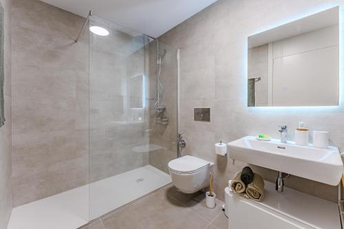 a bathroom with a shower and a toilet and a sink at Oceanfront Oasis - Stunning beach view apartment in El Médano