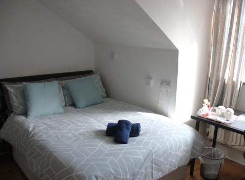 a bed with a blue stuffed animal on it at Parkfield Hotel in Bournemouth
