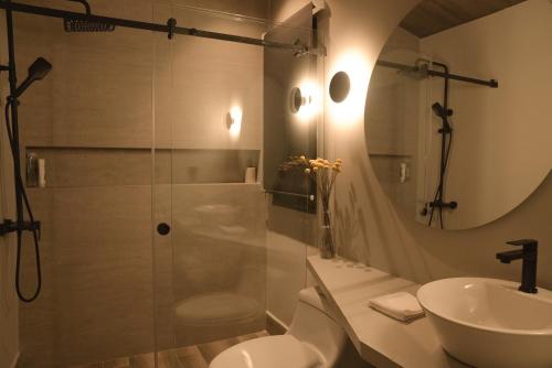 a bathroom with a shower and a toilet and a sink at Las Cabañas by PMJ in Cayambe